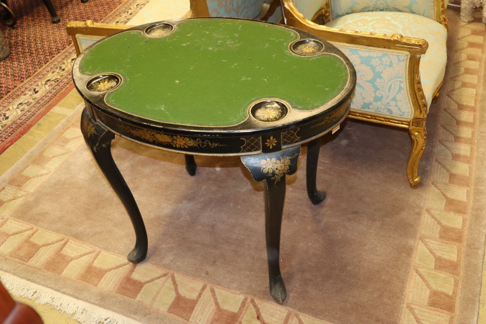 A 1920s oval chinoiserie lacquer card table, the removable top revealing a baize lined interior with four gilt decorated counter wells